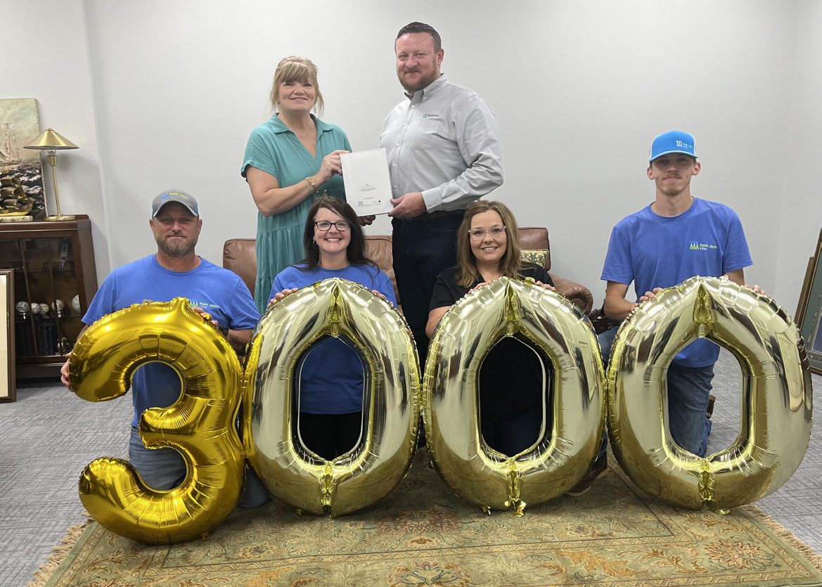 Petit Jean Fiber’s 3,000th subscriber winner reciving Ipad behind baloon numbers of 3000.